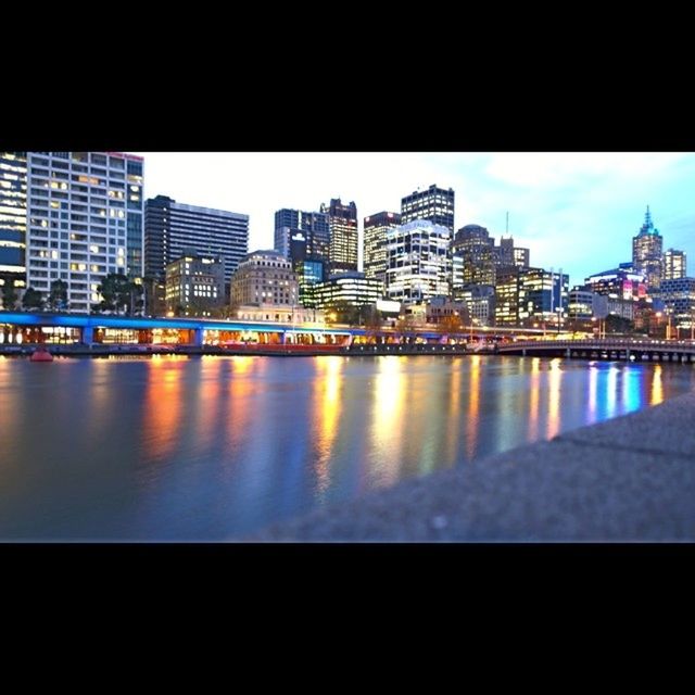 VIEW OF RIVER WITH CITYSCAPE IN BACKGROUND