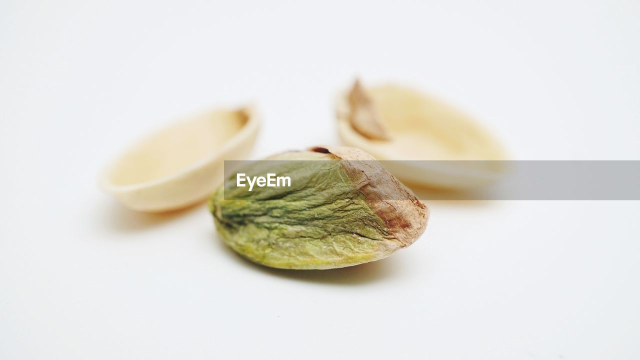 Close up image of pistachio and nut shell over white background