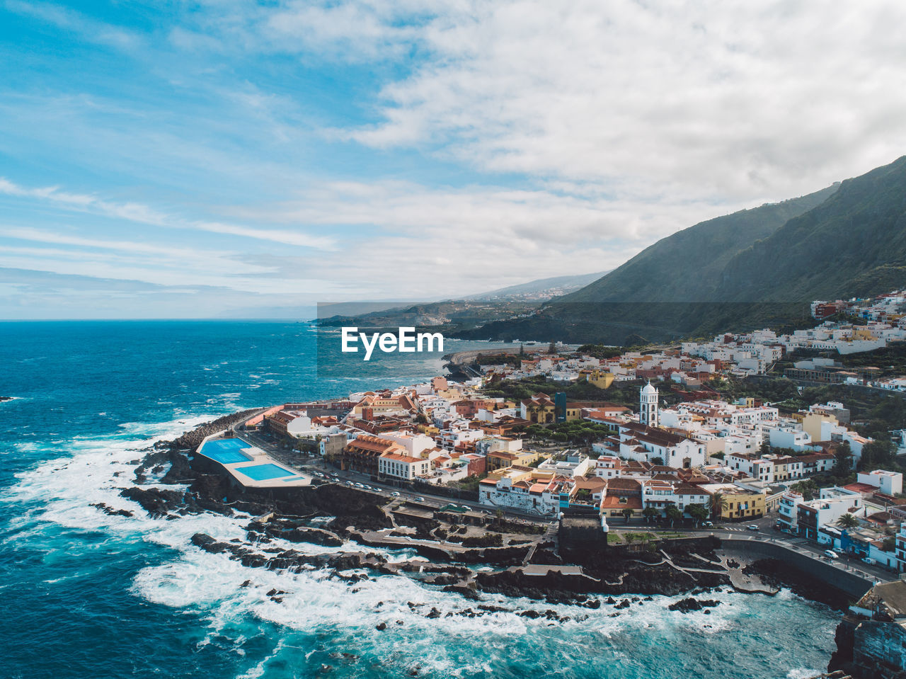 Aerial view of sea and buildings against sky