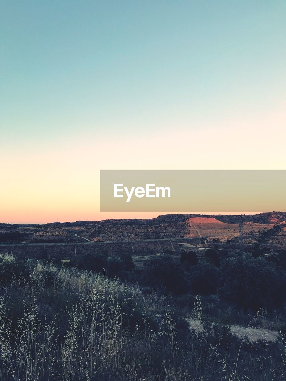 Scenic view of field against clear sky during sunset