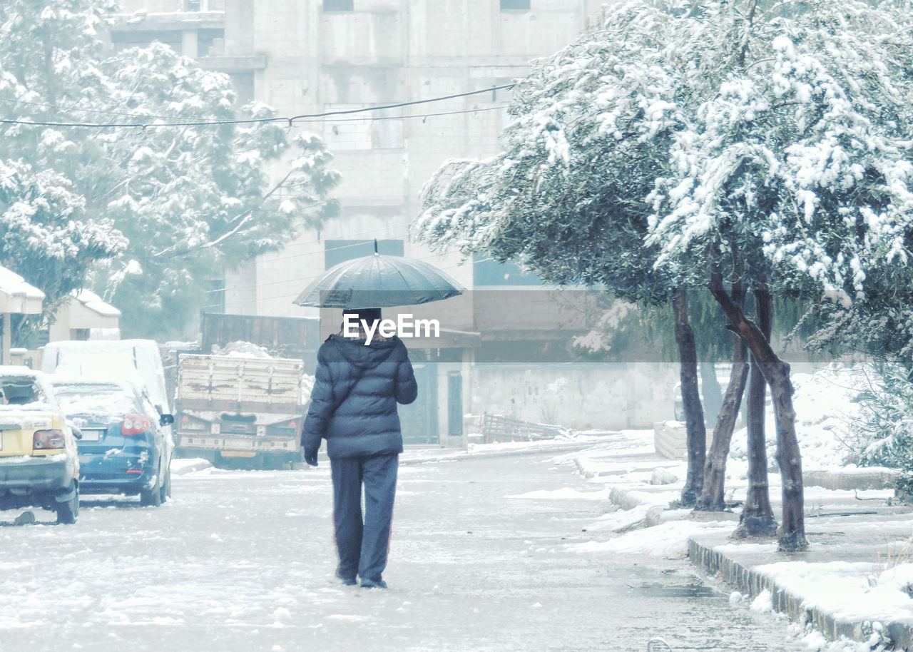 FULL LENGTH OF PERSON STANDING ON SNOW COVERED CITY