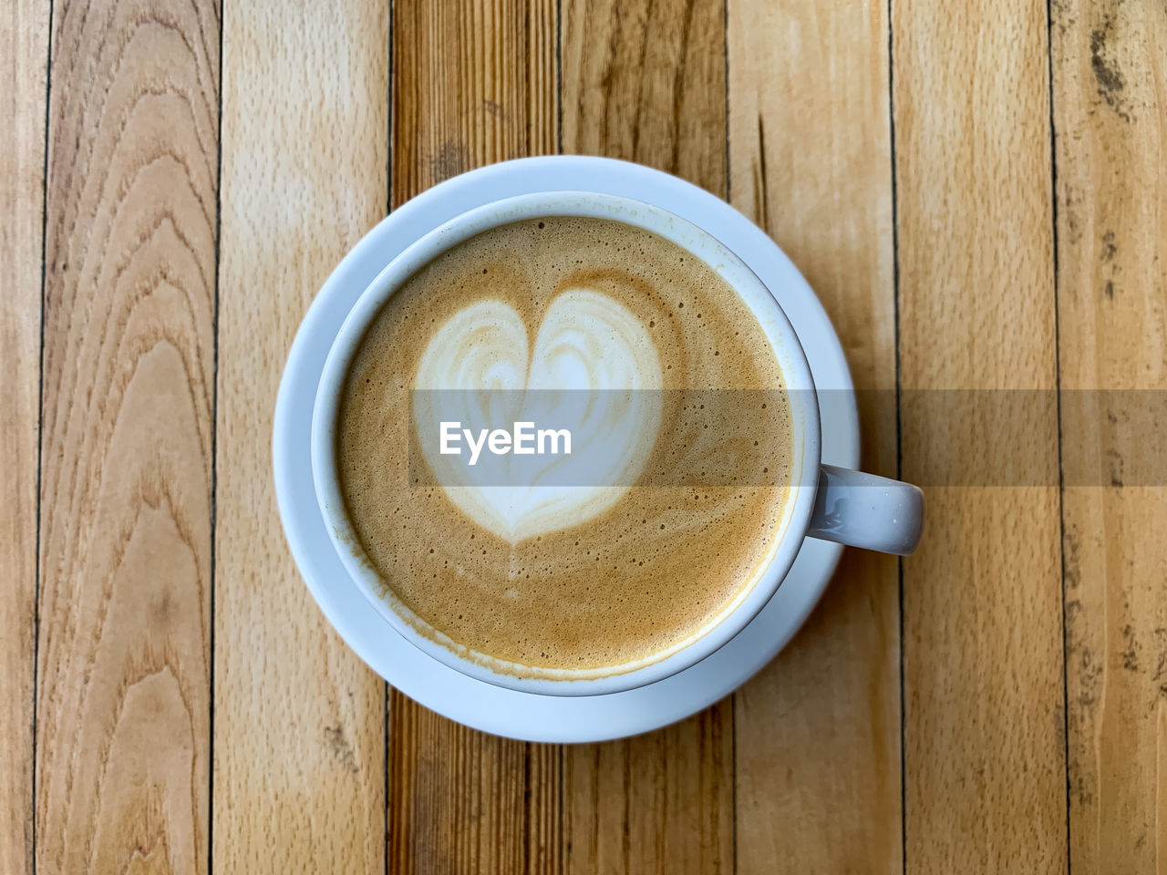 A cup of coffee latte on a wooden table. a mug of flat white coffee on a wooden background. coffee