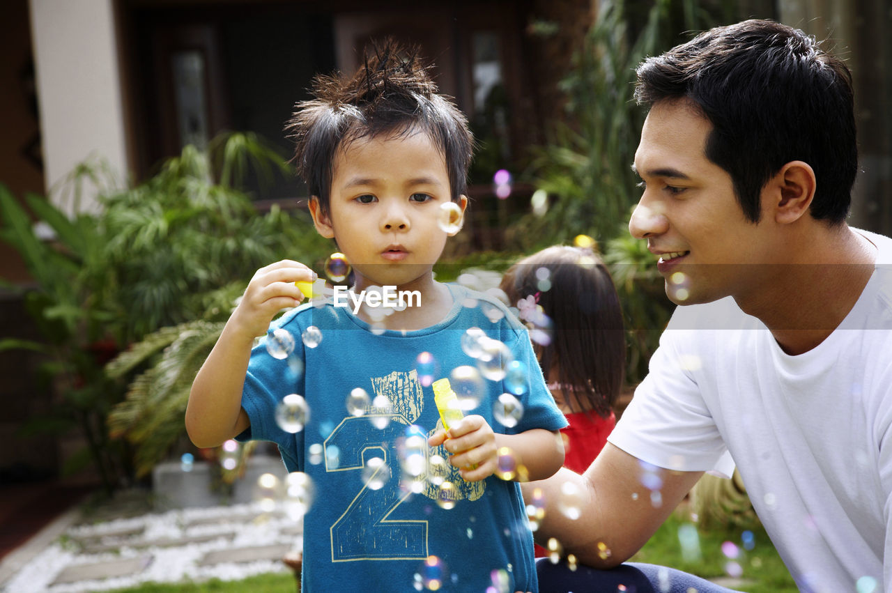 Close-up of family blowing bubble at park