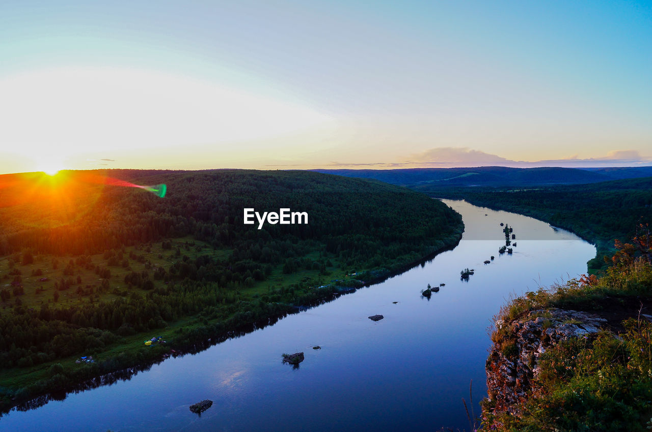 Scenic view of river against sky at sunset