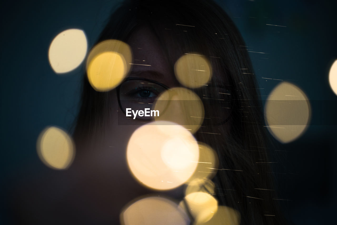 Close-up of defocused lights and young woman