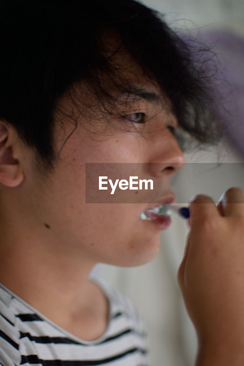 Close-up of man brushing teeth