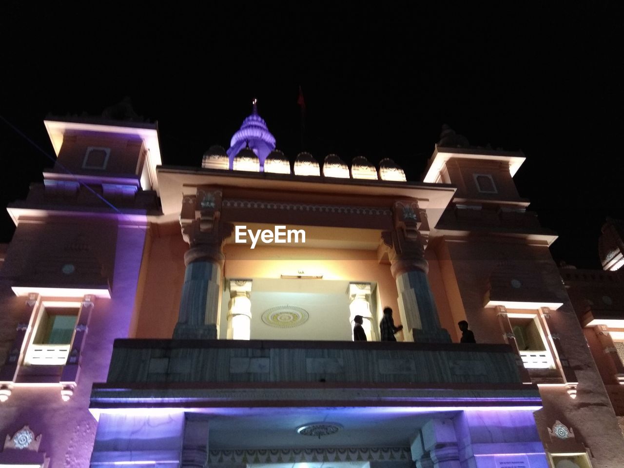 LOW ANGLE VIEW OF ILLUMINATED BUILDINGS AGAINST SKY AT NIGHT