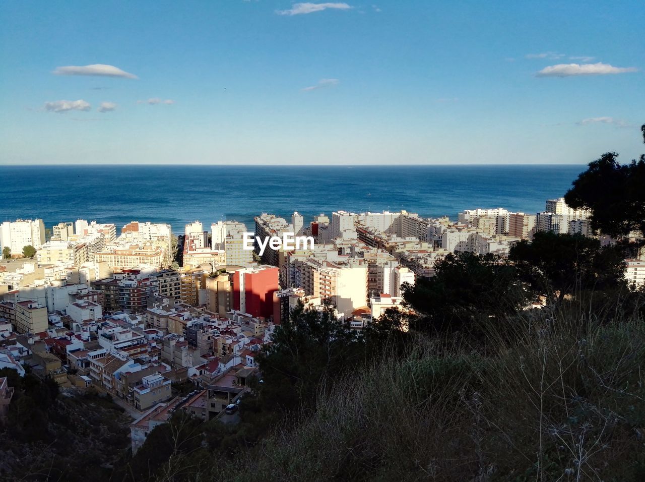 High angle view of townscape by sea against sky