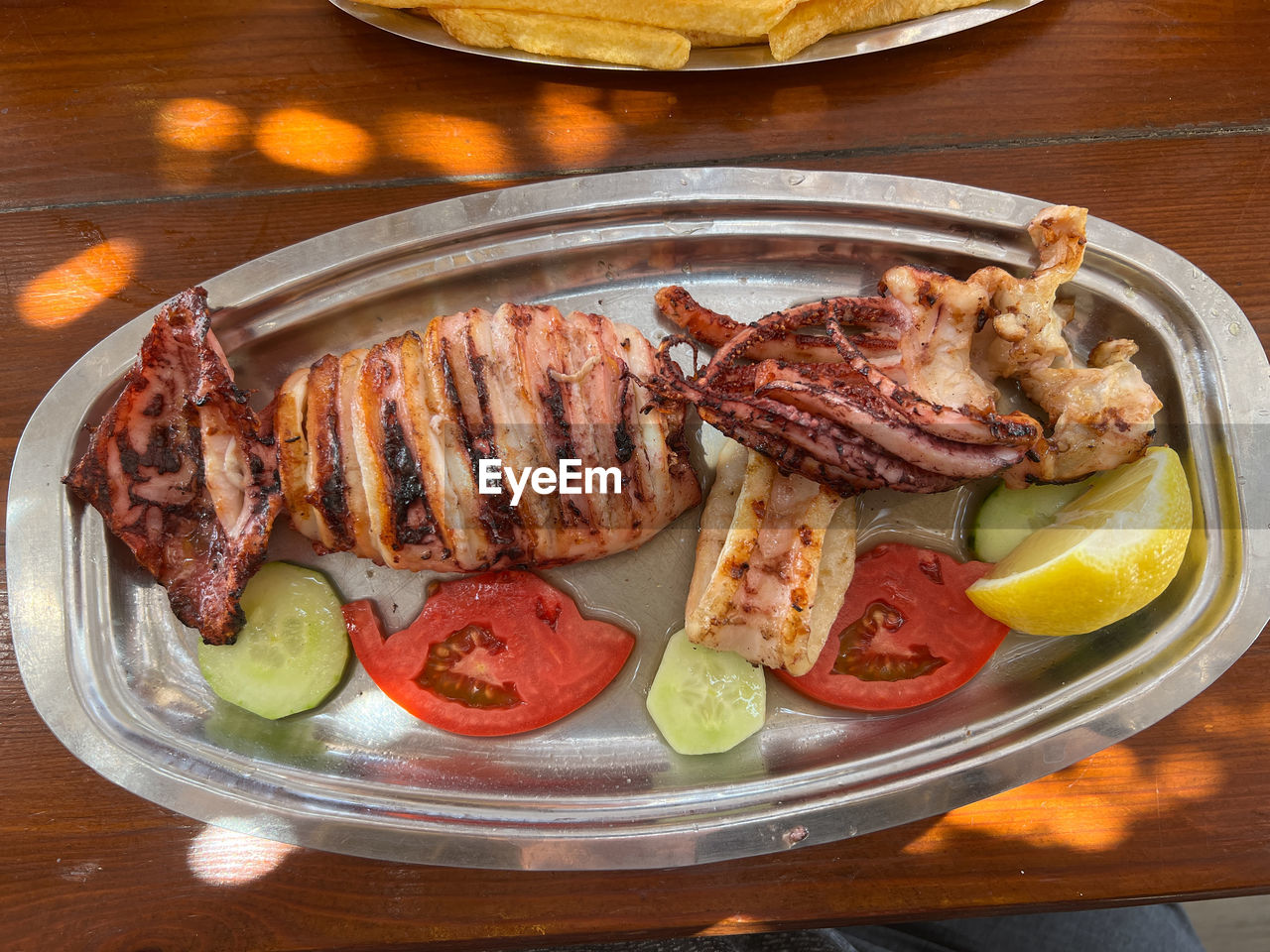 food, food and drink, meat, freshness, healthy eating, dish, meal, vegetable, fruit, barbecue, grilling, grilled, table, plate, no people, citrus fruit, dinner, roasted, fast food, lemon, wellbeing, slice, red meat, wood, cuisine, indoors, high angle view, beef, produce, tomato, lunch