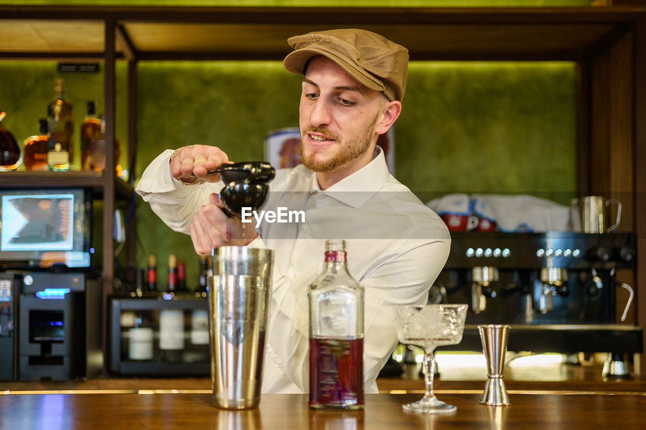 portrait of young man drinking wine in cafe