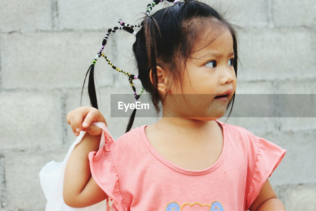 Close-up of girl against wall