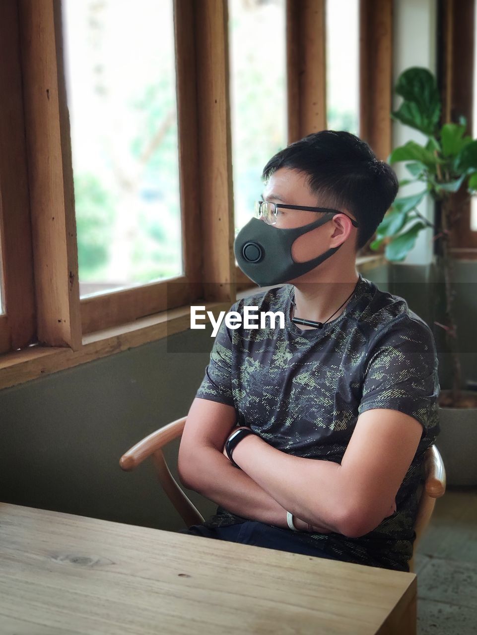 Man wearing mask while sitting on table at restaurant