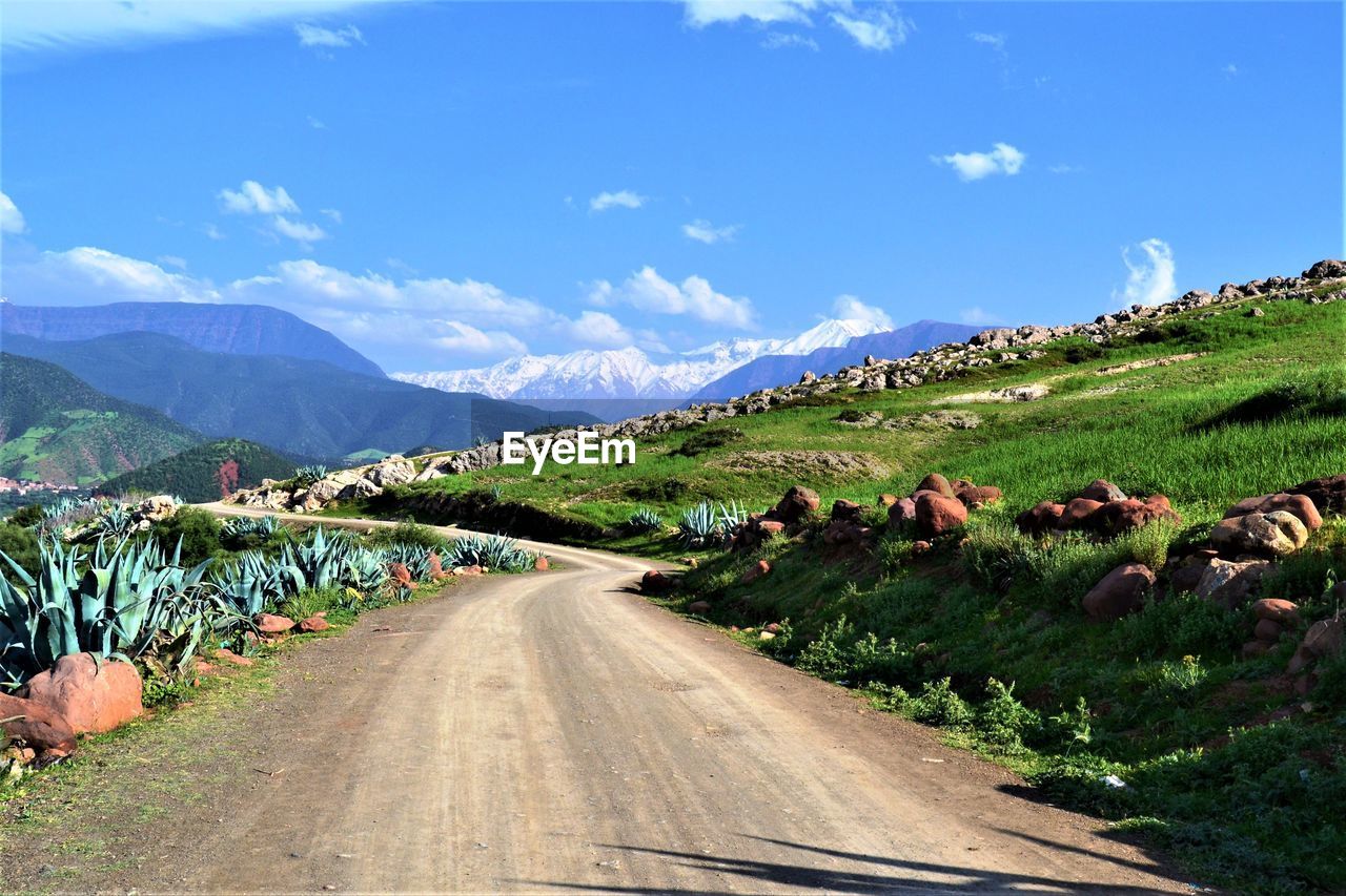 Road leading towards mountains against sky