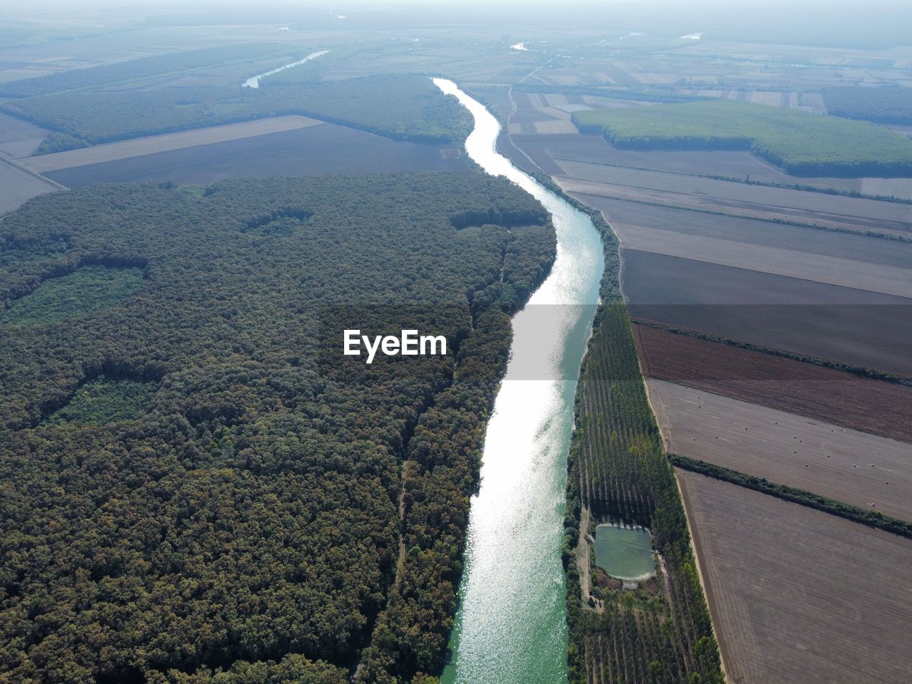 High angle view of river amidst land seen through airplane