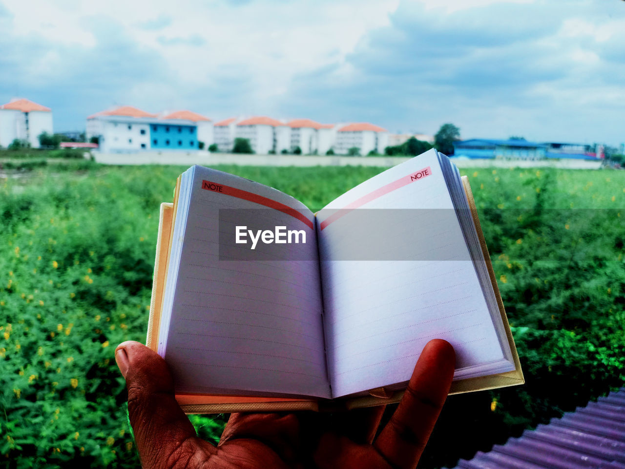 Cropped hand of person holding book