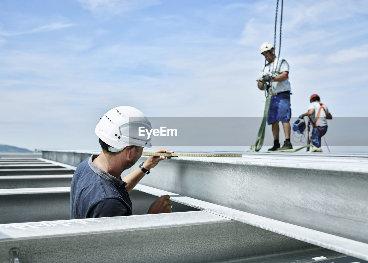Construction worker checking steel girder