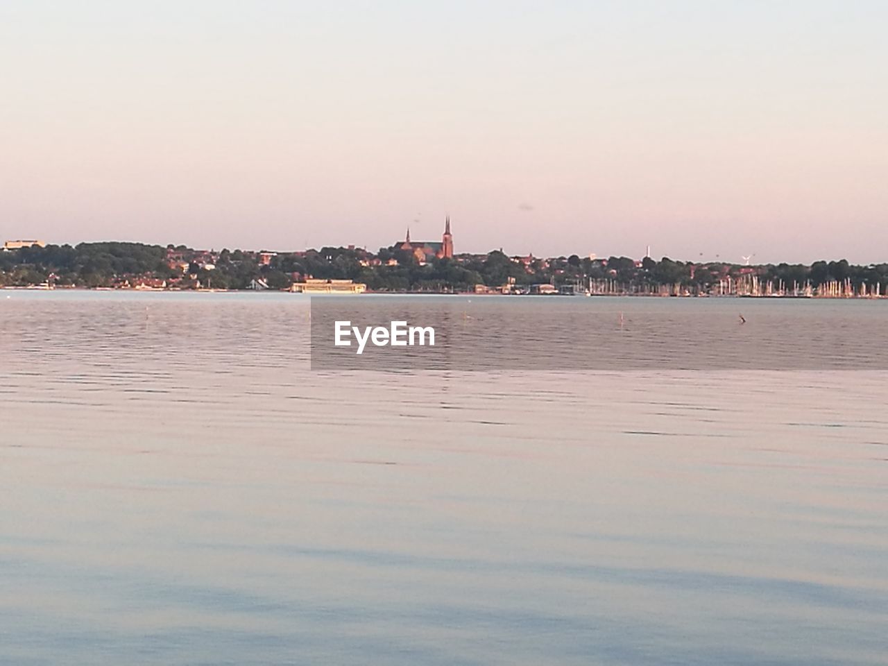 Scenic view of fjord by illuminated buildings against sky at dusk