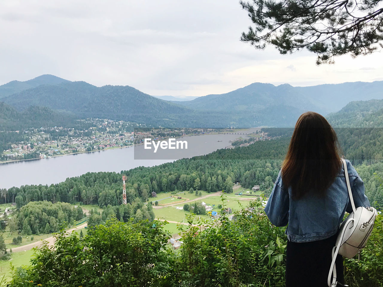 Rear view of woman looking at mountains against sky