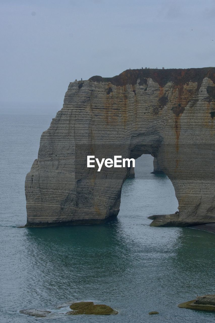 ROCK FORMATIONS IN SEA AGAINST SKY