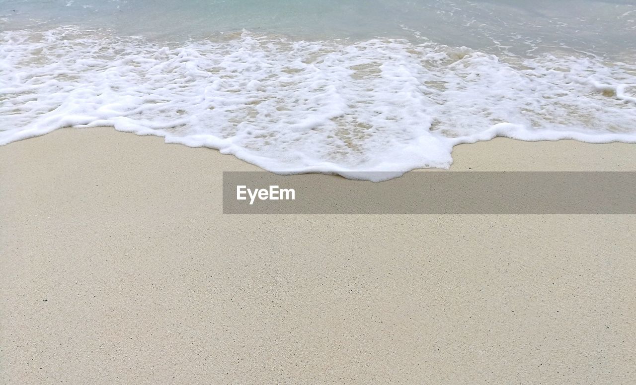 High angle view of waves rushing towards shore at beach