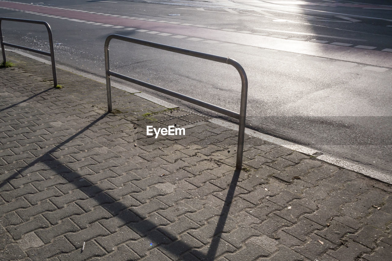 HIGH ANGLE VIEW OF FOOTPATH BY RAILING ON STREET