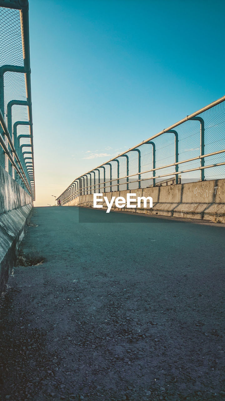 sky, architecture, bridge, built structure, blue, nature, railing, clear sky, no people, sea, water, transportation, line, reflection, walkway, day, horizon, outdoors, city, sunlight, copy space, staircase, metal, road