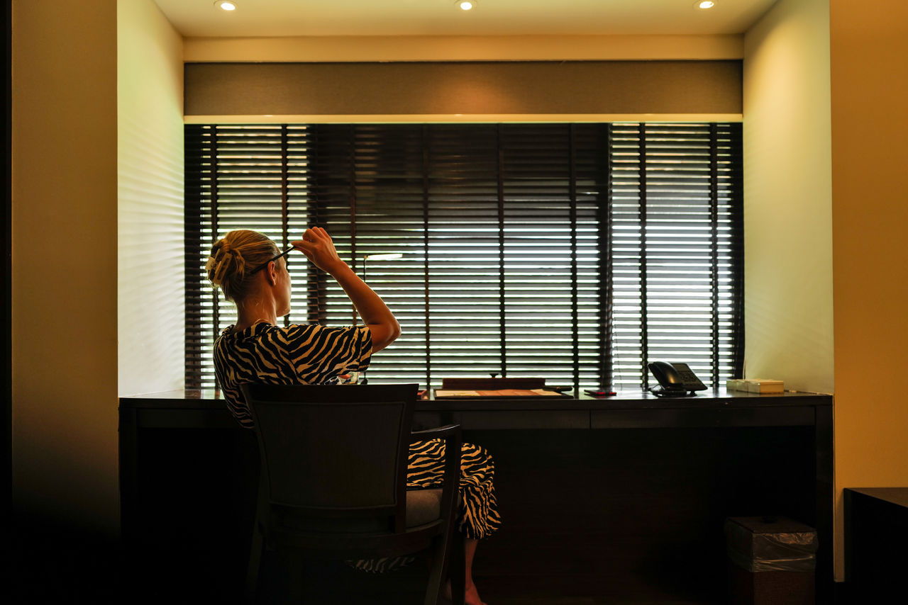 Woman sitting down next to the writing table making notes