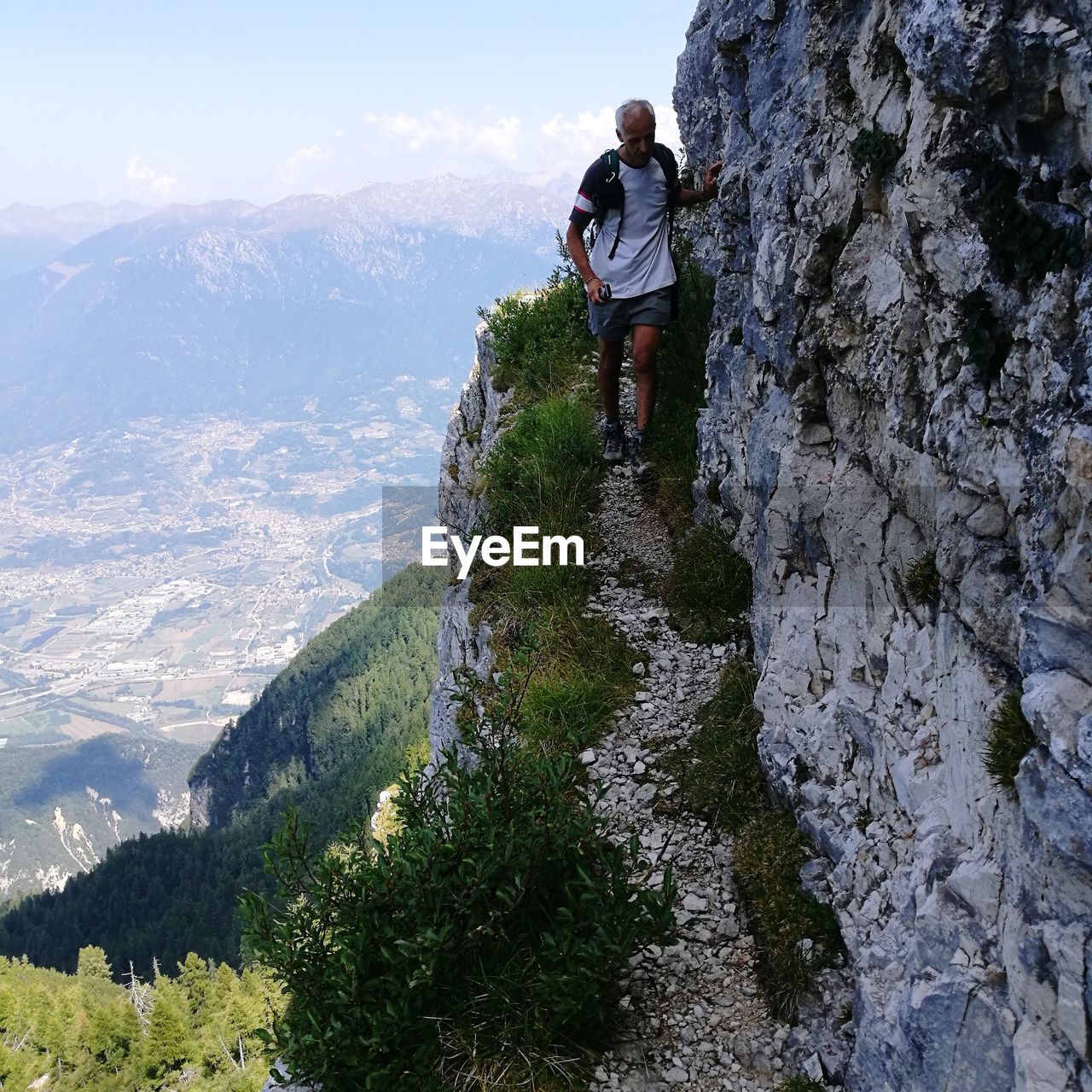 View of men hiking on rock against mountains