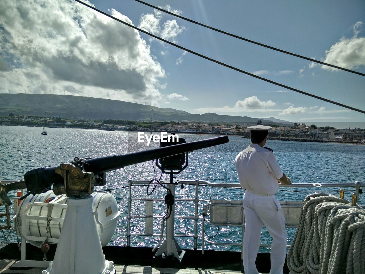 Rear view of boat captain on cruise over sea against sky