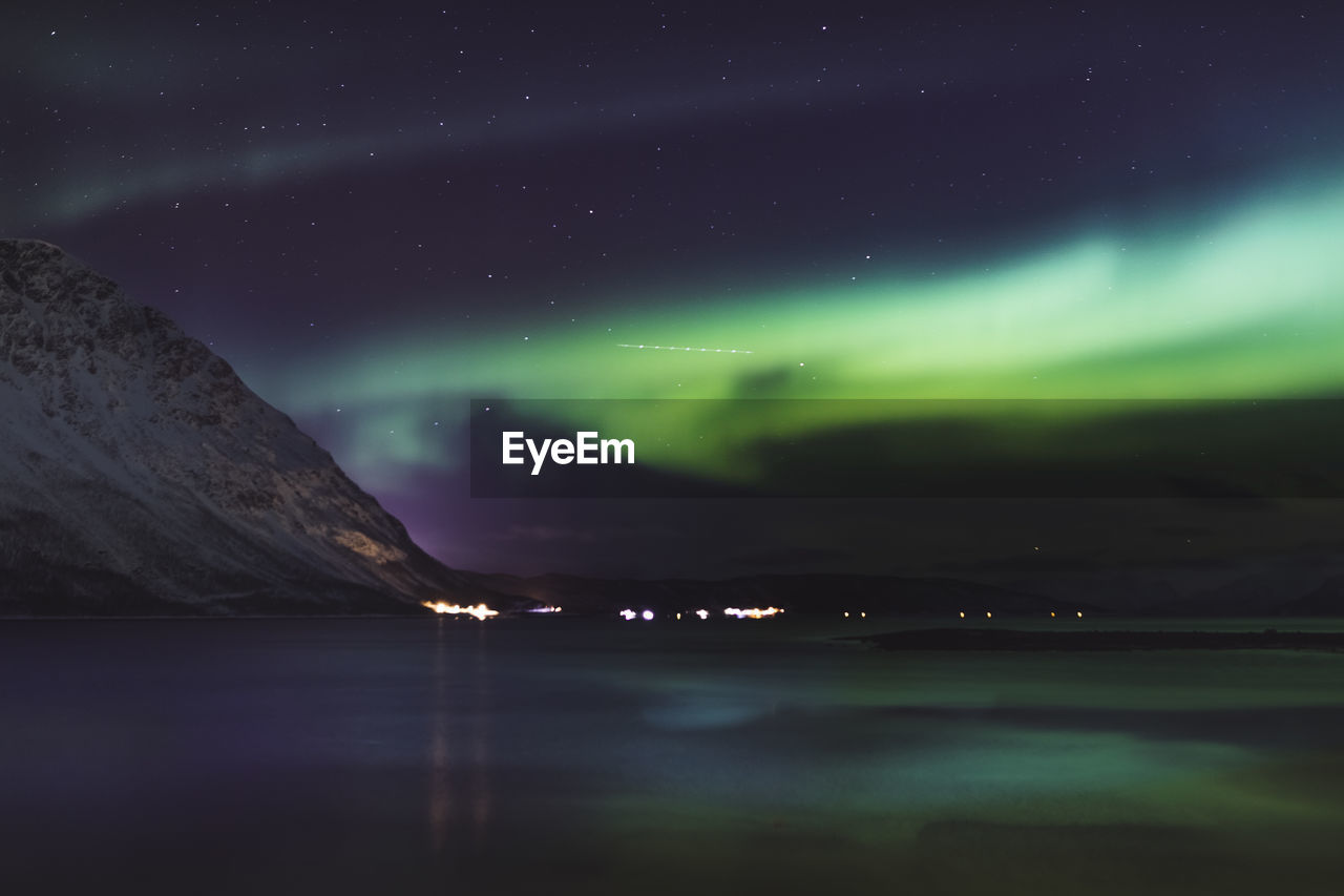 Scenic view of sea against sky 
aurora borealis at night