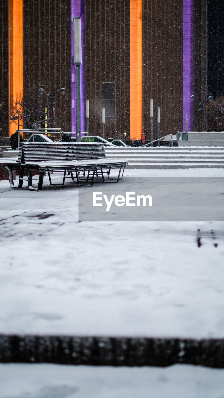 Empty bench on snowed ground