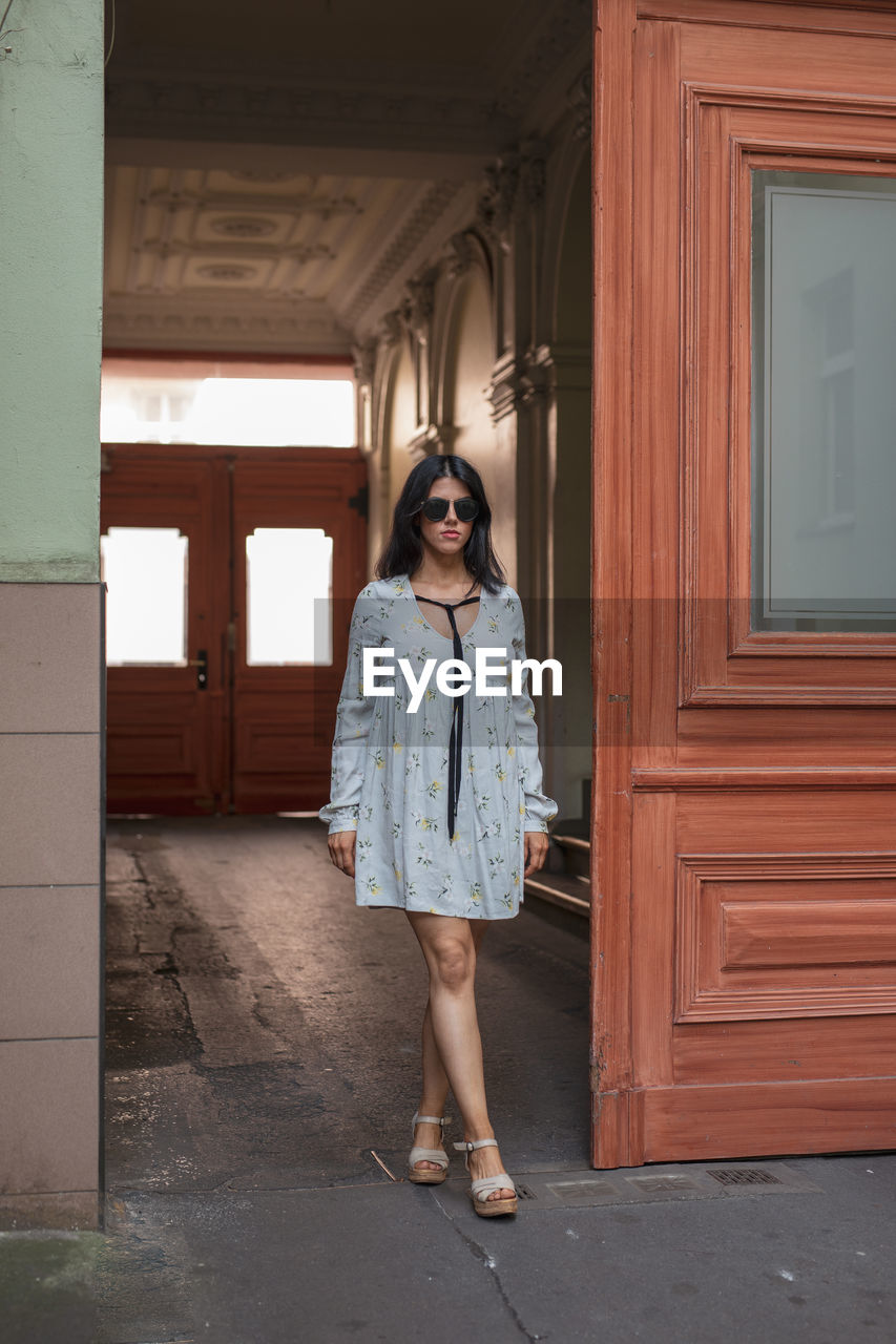 Full length of woman standing against door