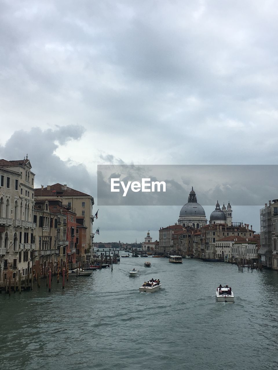 View of buildings in city against cloudy sky