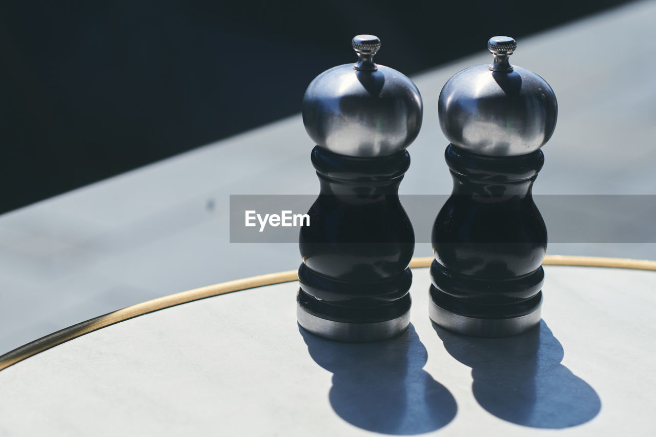 High angle view of salt and pepper shaker on table at sidewalk cafe