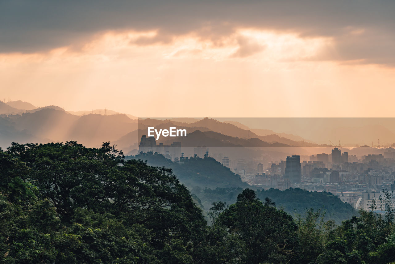 Scenic view of mountains against cloudy sky during sunset