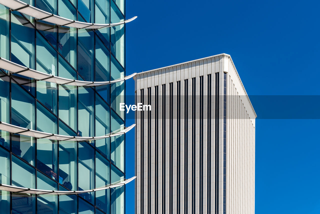 Low angle view of modern building against clear blue sky