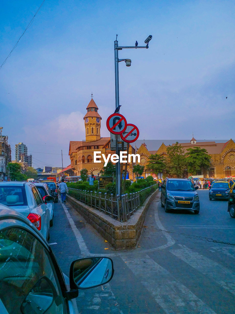 CARS ON ROAD BY BUILDING AGAINST SKY