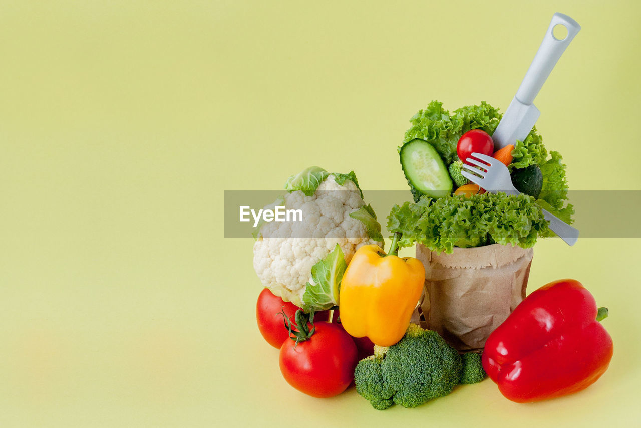 FRUITS AND VEGETABLES ON PLATE AGAINST GRAY BACKGROUND