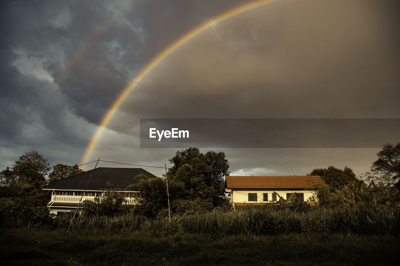 Scenic view of rainbow over buildings against sky