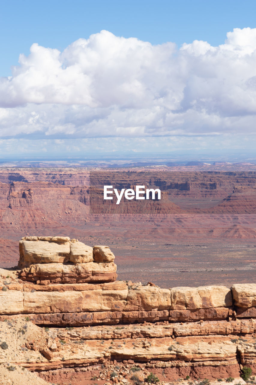 Rock formations on landscape against cloudy sky