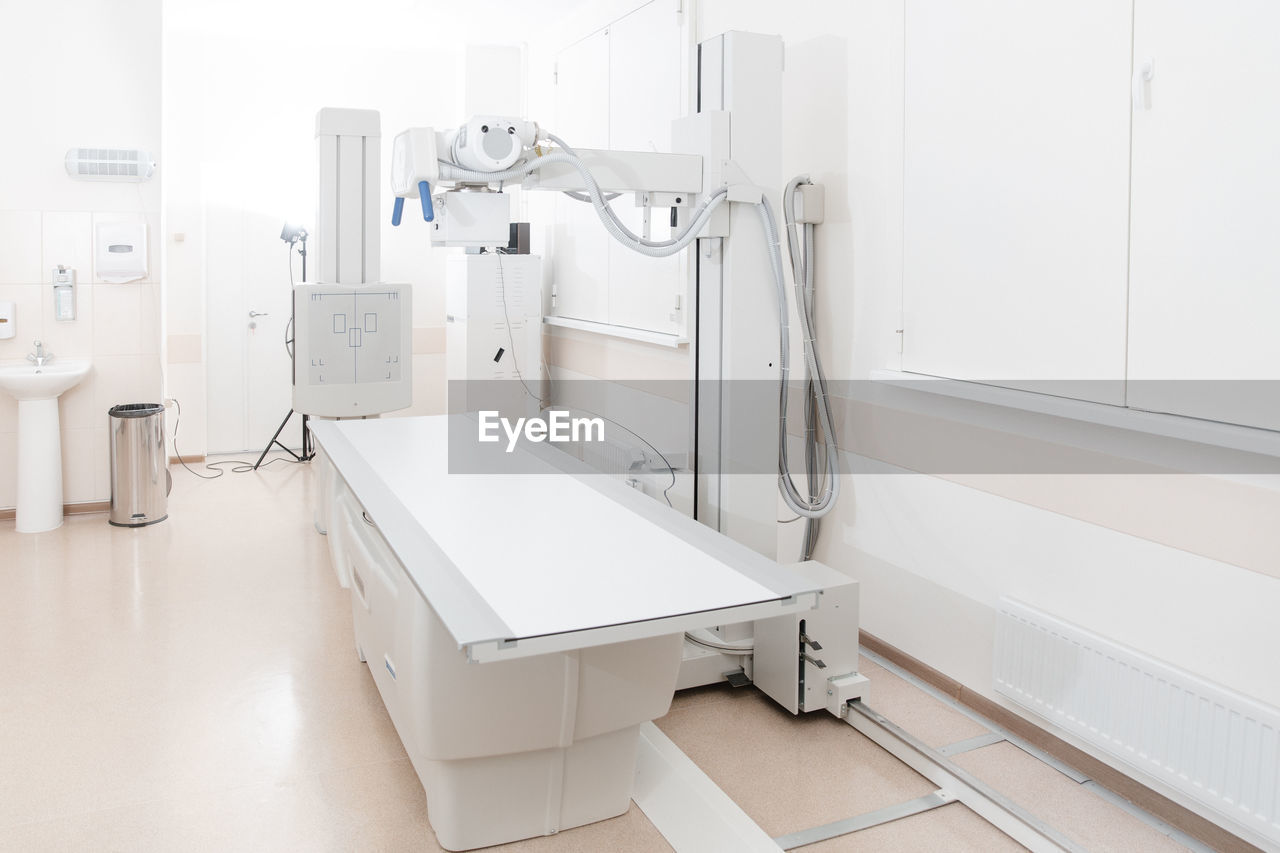 X-ray department in modern hospital. radiology room with scan machine with empty bed.