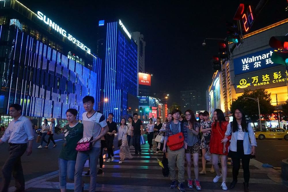 PEOPLE IN ILLUMINATED CITY AT NIGHT