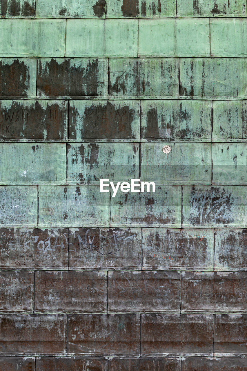 Oxidized copper folded sheet metal on roof. copper wall texture background. with marks and scrawls.