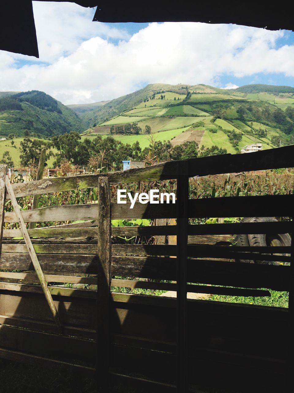 Wooden railing by mountains against sky