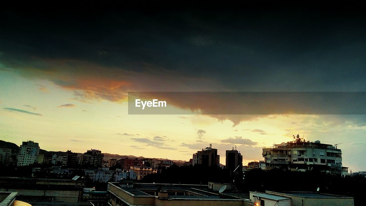 HIGH ANGLE VIEW OF BUILDINGS IN CITY AT SUNSET