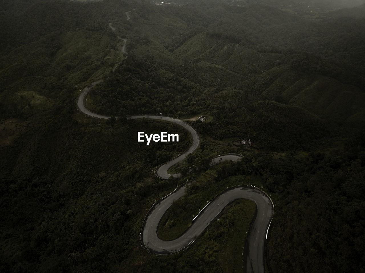 Countryside road passing through the lush green tropical rain forest mountain landscape