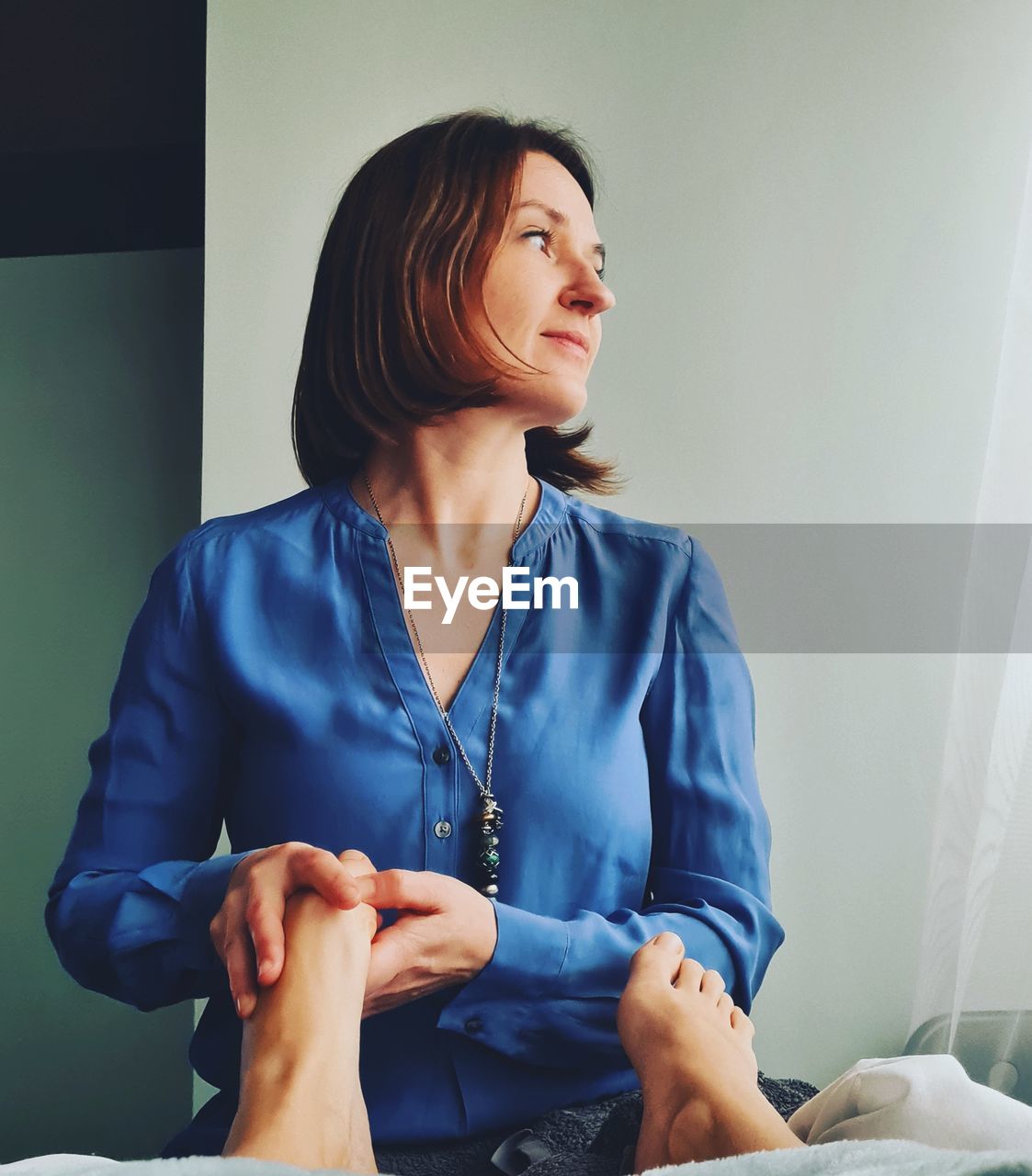 Young woman looking away while doing reflexology 