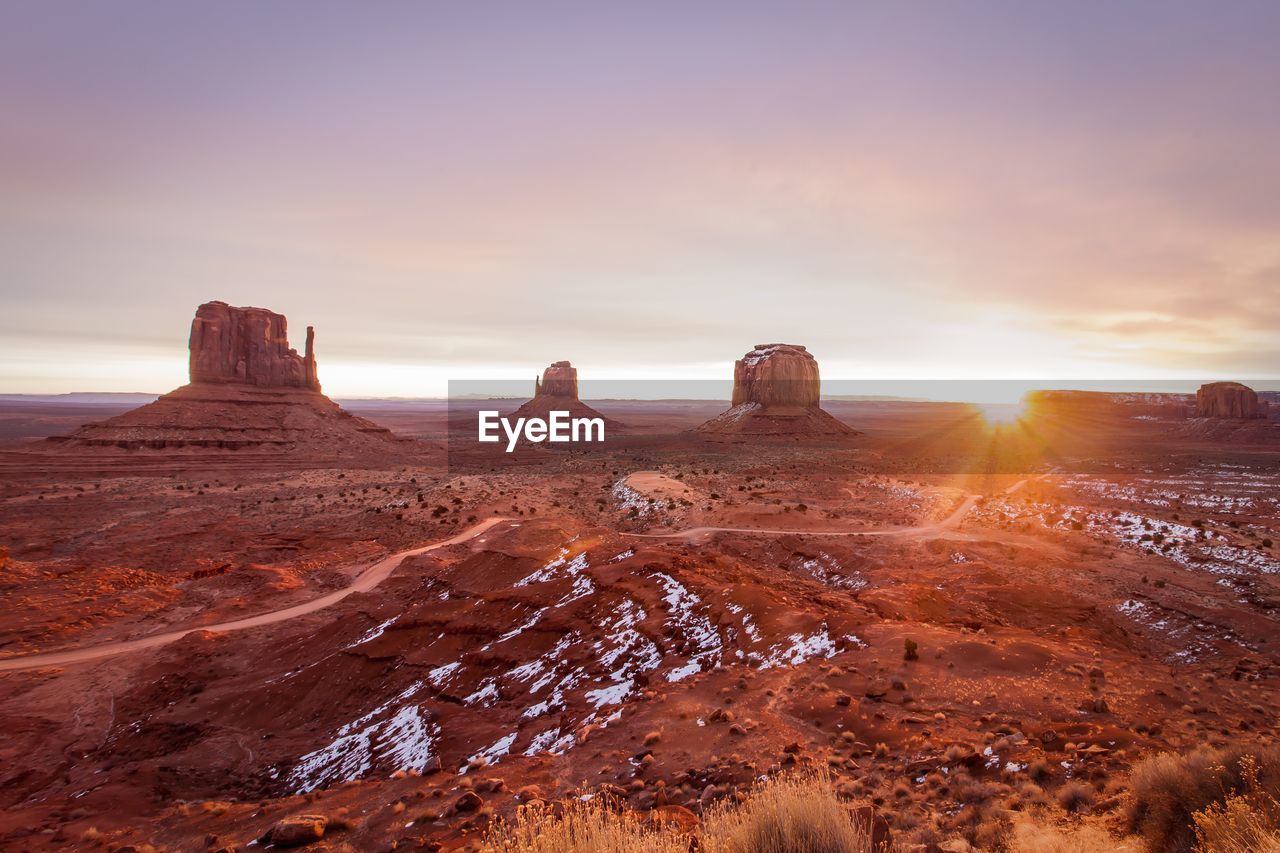 Rock formations on landscape against sky during sunset