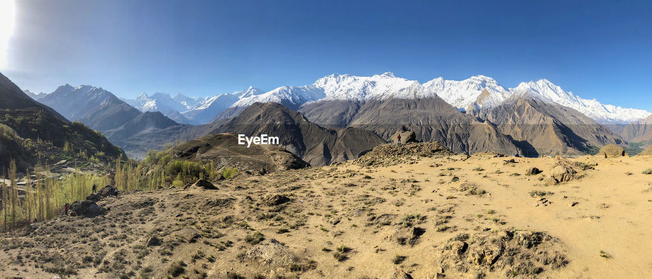 Panoramic view of snowcapped mountains against clear blue sky