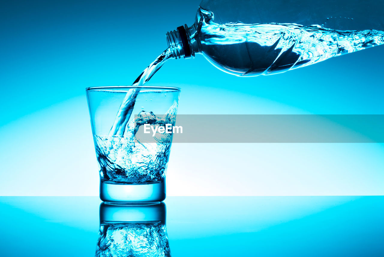 CLOSE-UP OF GLASS AGAINST BLUE WATER